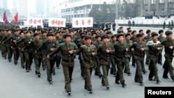 North Korean students attend a contest of singing wartime songs in chorus while marching in array, at Kim Il Sung square in Pyongyang in this picture released by the North's KCNA news agency March 17, 2013.