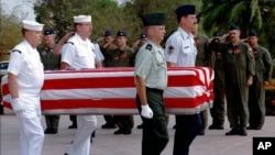 FILE PHOTO - Four U.S. servicemen carry a coffin containing the remains of U.S. servicemen from the Vietnam War era to an American military transport aircraft as U.S. pilots salute during a repatriation ceremony at the Phnom Penh airport Monday, Feb. 16, 1998. The remains discovered early this month have been linked to the crash of a U.S. Huey helicopter which flew into Cambodia with four crewmen on a rescue mission in March 1970 to pick up a special operations team in trouble. They will be brought to the Central Identification Laboratory in Hawaii for forensic analysis. (AP Photo/Ou Neakiry)