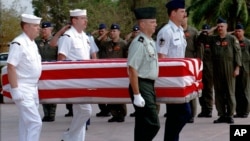 FILE PHOTO - Four U.S. servicemen carry a coffin containing the remains of U.S. servicemen from the Vietnam War era to an American military transport aircraft as U.S. pilots salute during a repatriation ceremony at the Phnom Penh airport.