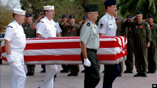 FILE PHOTO - Four U.S. servicemen carry a coffin containing the remains of U.S. servicemen from the Vietnam War era to an American military transport aircraft as U.S. pilots salute during a repatriation ceremony at the Phnom Penh airport.