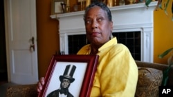 Ocea Thomas poses with a portrait of her ancestor, Samuel Burris, a free black man convicted of helping slaves escape in the 19th century. She reportedly has been told to expect a pardon for Burris, who died in 1863.