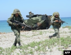 Philippine marines take position during an amphibious landing exercise at the beach of the Philippine navy training center facing the South China Sea in San Antonio town, Zambales province, north of Manila, Oct. 6, 2018. Japanese troops stormed a South China Sea beach in the Philippines in joint military exercises with US and Filipino troops that officials said marked the first time Tokyo's armored vehicles rolled on foreign soil after World War II.