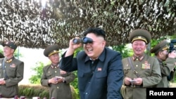 Lãnh tụ Bắc Triều Tiên Kim Jong Un dùng ống nhòm quan sát trận địa với các tướng lãnh.