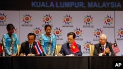 Thai Prime Minister Prayuth Chan-ocha, left, and Vietnam's Prime Minister Nguyen Tan Dung, center, sign documents as Malaysia's Prime Minister Najib Razak looks on during the signing ceremony of the 2015 Kuala Lumpur Declaration on the Establishment of th