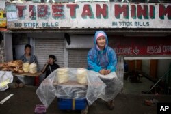 Pema Kyi, a 40-year-old exile Tibetan, sells Tibetan bread by the roadside in Dharmsala, India, June 20, 2017.