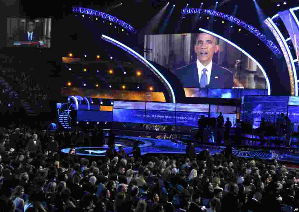 Presiden AS Barack Obama tampil di layar menyampaikan pidato mengenai imigrasi dari Gedung Putih pada awal acara tahunan Latin Grammy Awards ke-15 di MGM Grand Garden Arena, Las Vegas (20/11). (AP/Chris Pizzello)