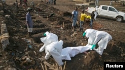 Health workers bury the body of a suspected Ebola victim at a cemetery in Freetown, Dec. 21, 2014. 