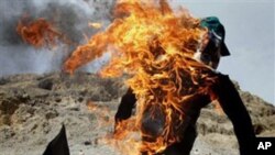An Afghan protester holds a burning effigy of American pastor Terry Jones during a demonstration in Nangarhar province, Afghanistan, April 4, 2011.