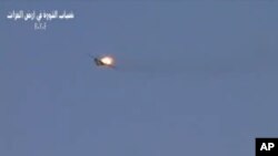 This image made from amateur video released by R.Y.E. Syria purports to show a Syrian plane downed over the eastern province of Deir el-Zour, Syria, August 13, 2012. 
