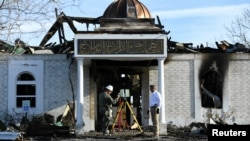 Security officials investigate the aftermath of a fire at the Victoria Islamic Center mosque in Victoria, Texas, Jan. 29, 2017. 