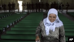 Seorang wanita mencari peti jenasah angoota keluarganya di antara 520 peti jenasah yang berhasil diidentifikasi sebagai korban Srebrenica di kompleks peringatan Potocari dekat Srebrenica, 160 kilometer sebelah timur Sarajevo, Bosnia dan Herzegovina (10/7