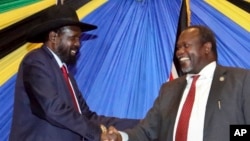 FILE - South Sudan's President Salva Kiir, left, shakes hands with rebel leader and former vice president Riek Machar after signing an agreement to reunify their political party in Arusha, Tanzania, Jan. 21, 2015. 