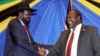 FILE - South Sudan's President Salva Kiir, left, shakes hands with rebel leader and former vice president Riek Machar after signing an agreement to reunify their political party in Arusha, Tanzania, Jan. 21, 2015. 
