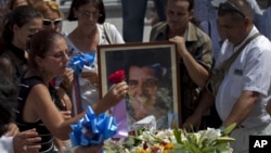 Bà Ofelia Acevedo, vợ nhà hoạt động Oswaldo Paya, đặt 1 bông hoa lên quan tài của chồng mình tại 1 nghĩa trang ở Havana, Cuba, 24/7/2012