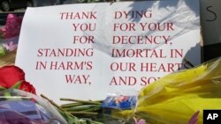 A sign of thanks rests against a traffic light pole at a memorial outside the transit center in Portland, Ore., May 27, 2017. People stopped with flowers, candles, signs and painted rocks for two bystanders who were stabbed to death Friday while trying to stop a man who was yelling anti-Muslim slurs and acting aggressively toward two young women on a light-rail train in Portland.