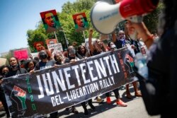 Des manifestants chantent alors qu'ils marchent après un rassemblement du Juneteenth au Brooklyn Museum, dans le quartier de Brooklyn à New York, le 19 juin 2020.