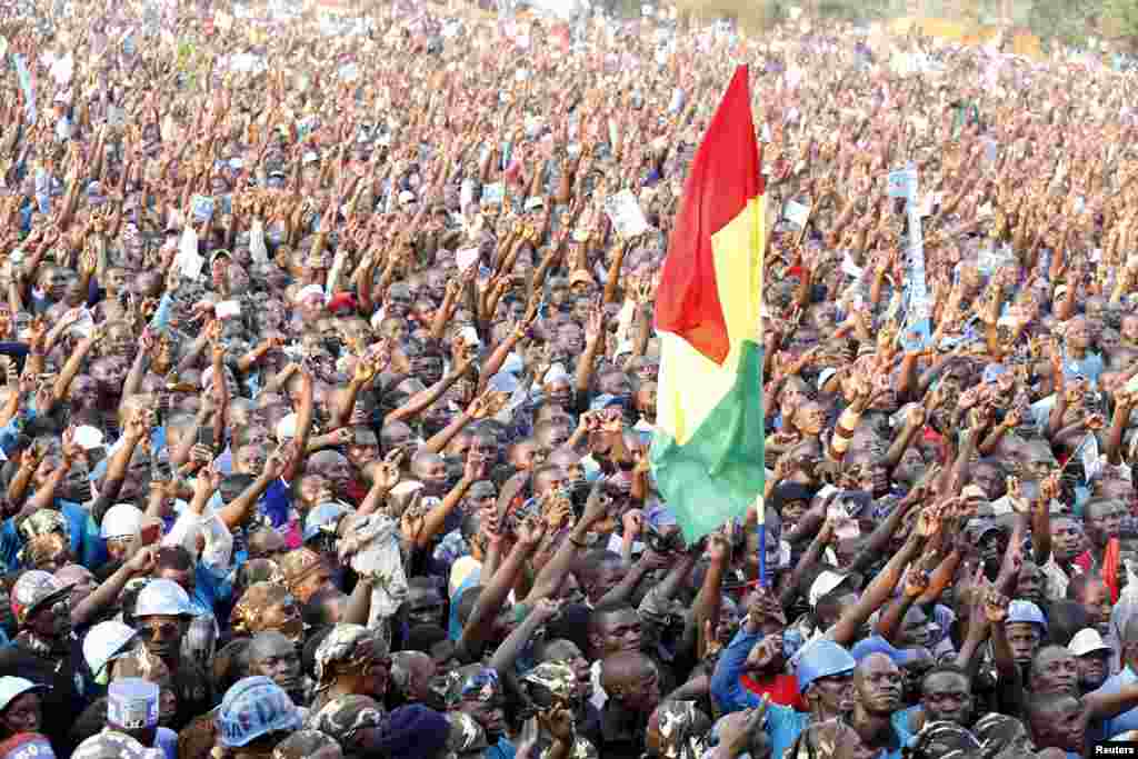 Para pendukung kandidat presiden oposisi Kizza Besigye dari Partai Forum Perubahan Demokrasi (FDC) memegang bendera saat kampanye di kota industri Jinja, di sebelah timur Uganda.