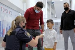 Seorang penduduk tetap Kanada dari Afghanistan berkumpul kembali dengan putranya yang berusia tiga tahun di bandara Toronto, Ontario, Kanada, 13 September 2021.