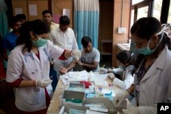 FILE - A patient has his blood taken to be tested at a fever clinic especially set up to cater to those suffering from fever, one of the main symptoms of several mosquito-borne diseases such as dengue, at a hospital in New Delhi, India, Sept. 15, 2016.