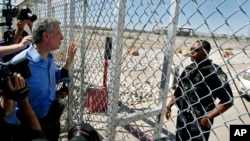 El alcalde de la ciudad de Nueva York, Bill de Blasio, izquierda, solicita entrada de una instalación de detención para niños inmigrantes en Tornillo, Texas, cerca de la frontera con México, el jueves 21 de junio de 2018. 