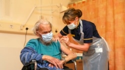 88 year old Trevor Cowlett receives the Oxford University/AstraZeneca COVID-19 vaccine from nurse Sam Foster at the Churchill Hospital in Oxford, southwest England on January 4, 2021