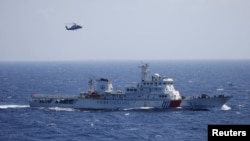 Chinese ship and helicopter are seen during a search and rescue exercise near Qilian Yu subgroup in the Paracel Islands, which is known in China as Xisha Islands, South China Sea, July 14, 2016.
