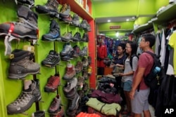 FILE - Tourists from Singapore visit the Everest Base Camp shop for trekking gear in Kathmandu, Nepal, April 20, 2016. After two hard years for mountaineering, more than 200 climbers have scaled the daunting mountain in the past 10 days, sending a wave of