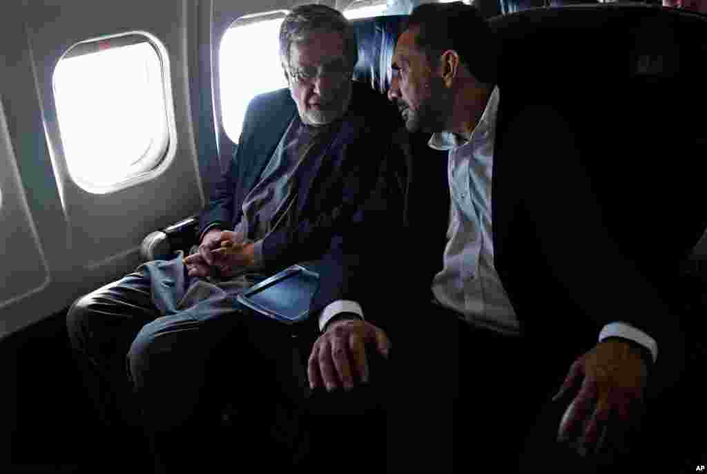 Presidential candidate and former foreign minister Zalmai Rassoul (left) and his first vice-presidential candidate, Ahmad Zia Massoud (right) speak on a plane en route to Kabul, March 30, 2014.