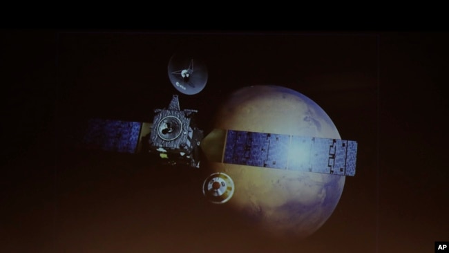 A artist rendering of the Schiaparelli Space Module and of the planet Mars is displayed on a movie screen, during an event on the occasion of the insertion of the Trace Gas Orbiter into orbit around Mars.