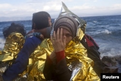 A Syrian refugee wrapped in a thermal blanket looks on, following her arrival on an overcrowded dinghy on the Greek island of Lesbos after crossing a part of the Aegean Sea from the Turkish coast, Sept. 30, 2015.