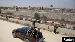 Members of the Hamas security forces ride in a pickup truck as they patrol the border area between Gaza and Egypt, in the southern Gaza Strip, May 20, 2013.
