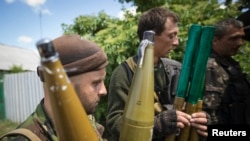 Pro-Russian separatists hold rocket-propelled grenade projectiles in Siversk, Donetsk region, June 19, 2014.