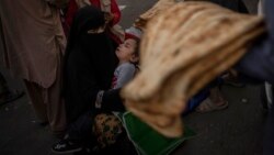 FILE - An Afghan woman begs at a market in Kabul's Old City, Afghanistan, Sept. 14, 2021.