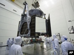 Technicians lower NASA's Juno spacecraft onto a fueling stand at Astrotech's Hazardous Processing Facility in Titusville, Florida, June 27, 2011