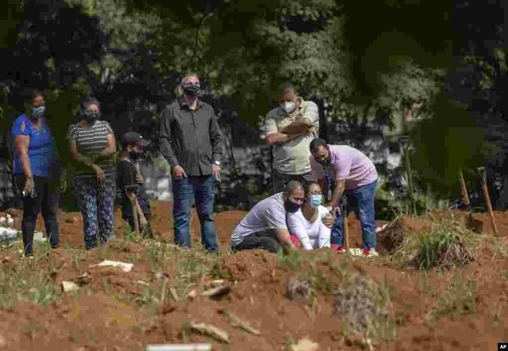 Family members attend a burial service of a person who died from health issues related to COVID-19 at the Vila Formosa cemetery in Sao Paulo, Brazil.