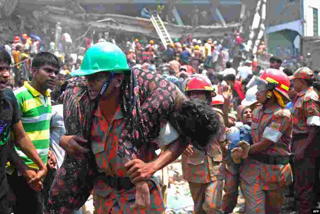 Seorang petugas pemadam kebakaran menggendong seorang pekerja garmen yang terluka dari reruntuhan bangunan berlantai delapan yang ambruk di Savar, di Dhaka, Bangladesh 24 April 2013.