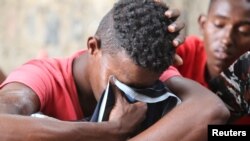 FILE - A Somali refugee, who was among survivors of an attack on a boat off Yemen's coast in the Red Sea, cries as he sits at a detention center in the Houthi-held port of Hodeidah, Yemen, March 22, 2017.