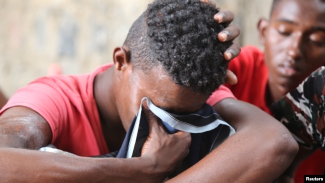 FILE - A Somali refugee, who was among survivors of an attack on a boat off Yemen's coast in the Red Sea, cries as he sits at a detention center in the Houthi-held port of Hodeidah, Yemen, March 22, 2017.