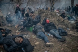 Para mingran duduk dekat perbatasan Turki-Yunani di Pazarkule, distrik Edime, 29 Februari 2020. (Foto: AFP)