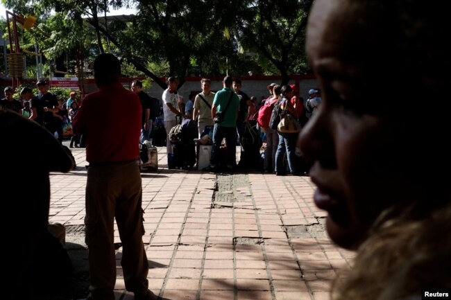 Personas que viajan en autobús desde Caracas a Ecuador hacen fila para sellar sus pasaportes en la oficina de control de migración en San Antonio del Táchira, Venezuela, el 8 de noviembre de 2017.