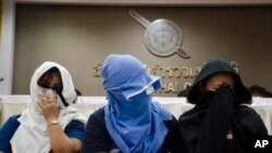 FILE - Unidentified Thai suspects of human trafficking appear at a news conference at police headquarters in Bangkok, Thailand, Aug. 4, 2015.