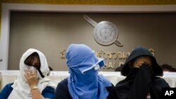 Unidentified Thai suspects of human trafficking appear at a news conference at police headquarters in Bangkok, Thailand, Aug. 4, 2015.