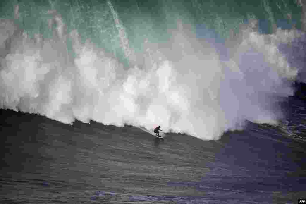 Brazilian surfer Marcelo Luna rides a wave during the first surf session of 2018 at Praia do Norte in Nazare, Portugal.