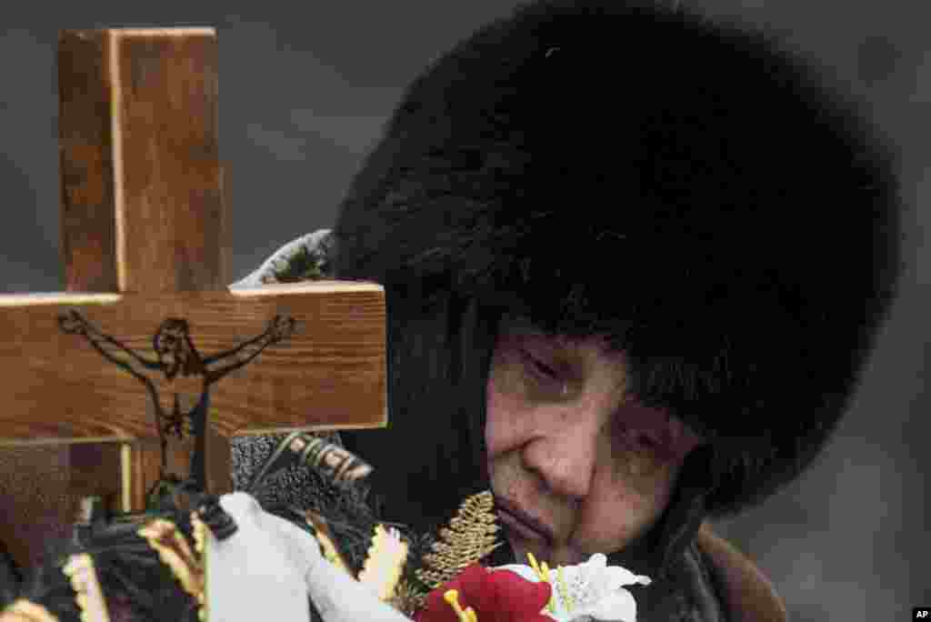 The mother of Elena Volkova, a victim of shelling, cries at her daughter&#39;s grave during her funeral in Avdiivka, eastern Ukraine.