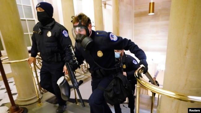 Polisi Gedung Kongres AS siap siaga sementara para pendukung Trump memasuki Gedung Kongres, Rabu (6/1).