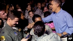 President Barack Obama greets members of the military as he arrives with the first family on Air Force One at Joint Base Pearl Harbor-Hickam, in Honolulu, Hawaii, Dec. 20, 2013. 