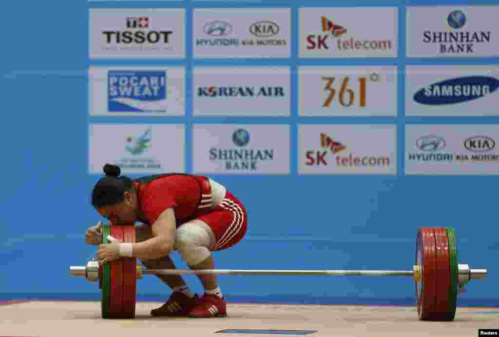 Kazakstan's Zhazira Zhapparkul kisses the weights after lifting 145kg on her third attempt in the women's clean and jerk 75kg weightlifting competition at the Moonlight Garden Venue during the 17th Asian Games in Incheon, South Korea.