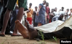 FILE - Residents look at the slain bodies of people killed at the Cibitoke district in Burundi's capital Bujumbura, December 9, 2015.