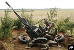 In this photo taken Sept. 14, 2017, Belarus' soldiers aim an anti-aircraft gun at a training ground at an undisclosed location in Belarus. Russia and Belarus began major war games this week thousands of troops, tanks and aircraft.