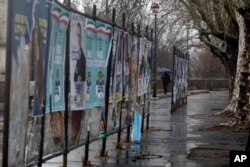 Torn electoral posters hang on billboard in Rome, March 5, 2018.